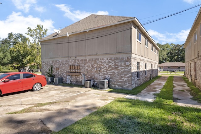 700 Lyle W Ave Unit B, Cleveland, TX 77327 - view of property exterior with brick siding, central air condition unit, and roof with shingles