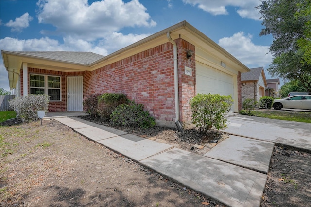 12903 Belmont Legend Ct, Houston, TX 77047 - view of side of home with brick siding, a garage, driveway, and a shingled roof