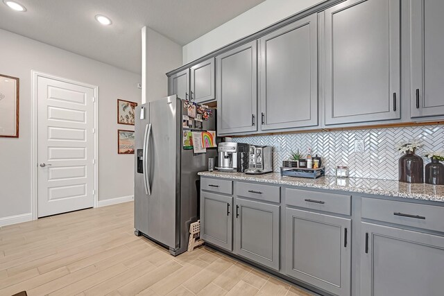 2104 Terra Rose Dr, Katy, TX 77493 - kitchen featuring stainless steel refrigerator with ice dispenser, gray cabinetry, light wood finished floors, backsplash, and baseboards