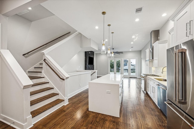 1518 Houston Ave, Houston, TX 77007 - kitchen featuring high end appliances, a center island, dark wood finished floors, white cabinets, and recessed lighting