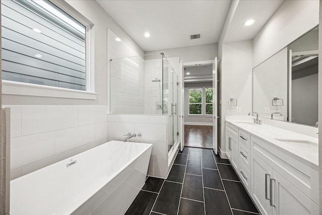 1518 Houston Ave, Houston, TX 77007 - full bathroom featuring a freestanding bath, a stall shower, double vanity, recessed lighting, and tile patterned flooring