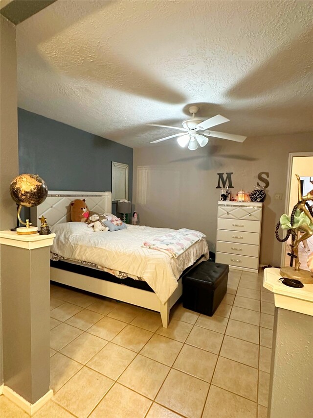 117 Lasso St, Angleton, TX 77515 - bedroom featuring light tile patterned floors, a textured ceiling, and a ceiling fan