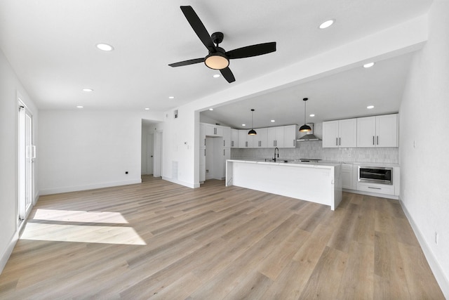 13014 John Reynolds Rd, Galveston, TX 77554 - unfurnished living room featuring a sink, recessed lighting, ceiling fan, light wood-type flooring, and baseboards