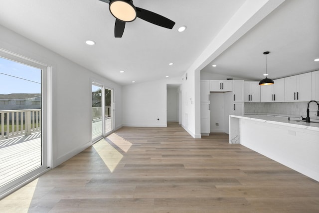 13014 John Reynolds Rd, Galveston, TX 77554 - unfurnished living room featuring a ceiling fan, vaulted ceiling, recessed lighting, baseboards, and light wood finished floors
