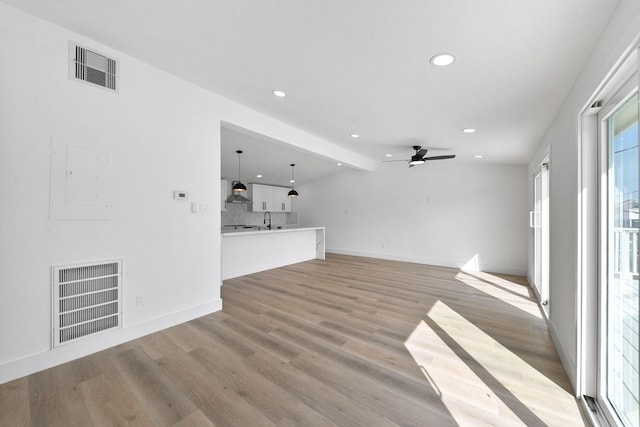 13014 John Reynolds Rd, Galveston, TX 77554 - unfurnished living room featuring recessed lighting, a ceiling fan, light wood-style flooring, baseboards, and electric panel