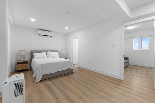 13014 John Reynolds Rd, Galveston, TX 77554 - bedroom with a wall mounted AC, light wood finished floors, recessed lighting, and baseboards