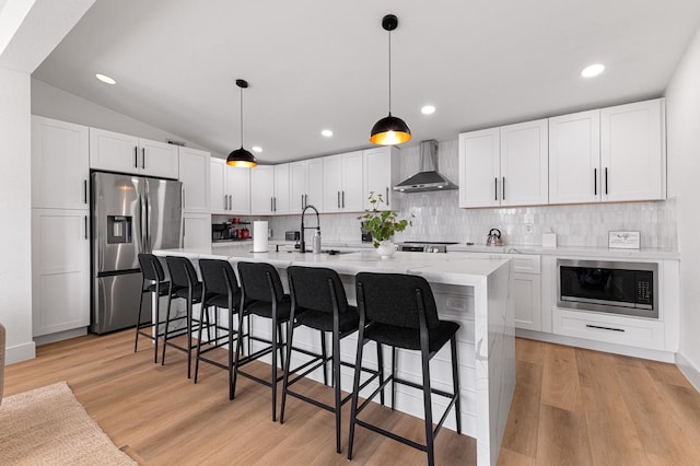 13014 John Reynolds Rd, Galveston, TX 77554 - kitchen featuring stainless steel refrigerator with ice dispenser, wall chimney range hood, built in microwave, a sink, and decorative backsplash