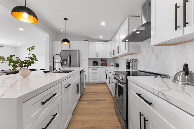 13014 John Reynolds Rd, Galveston, TX 77554 - kitchen with wall chimney exhaust hood, appliances with stainless steel finishes, white cabinets, a sink, and light wood-style flooring