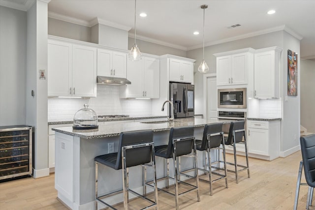 706 Olive St Unit B, Houston, TX 77007 - kitchen featuring beverage cooler, a sink, under cabinet range hood, stainless steel fridge with ice dispenser, and built in microwave