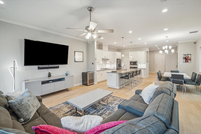 706 Olive St Unit B, Houston, TX 77007 - living room featuring ornamental molding, recessed lighting, a ceiling fan, light wood-style floors, and a chandelier