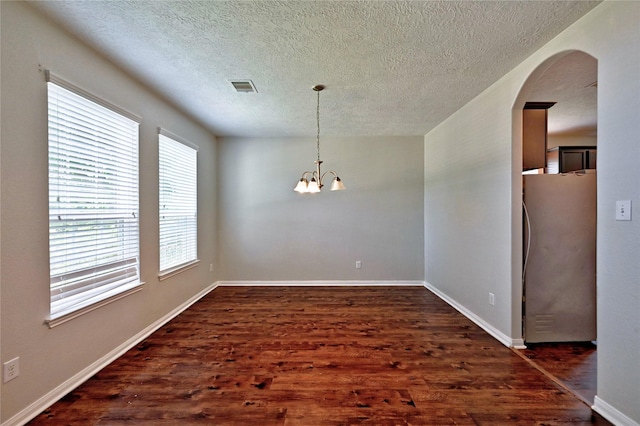 20610 Arrow Falls Ln, Richmond, TX 77407 - spare room with a chandelier, dark wood finished floors, arched walkways, a textured ceiling, and baseboards