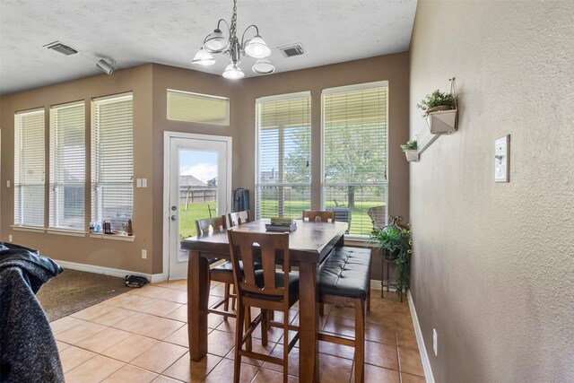 1814 Caroline Ave, Baytown, TX 77523 - dining area with a textured wall, baseboards, light tile patterned flooring, a chandelier, and a textured ceiling