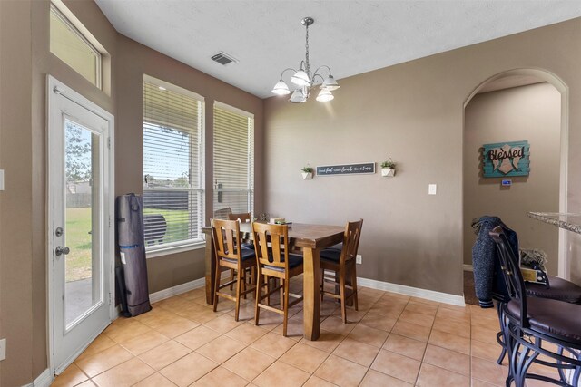 1814 Caroline Ave, Baytown, TX 77523 - dining area with baseboards, a chandelier, light tile patterned floors, and arched walkways