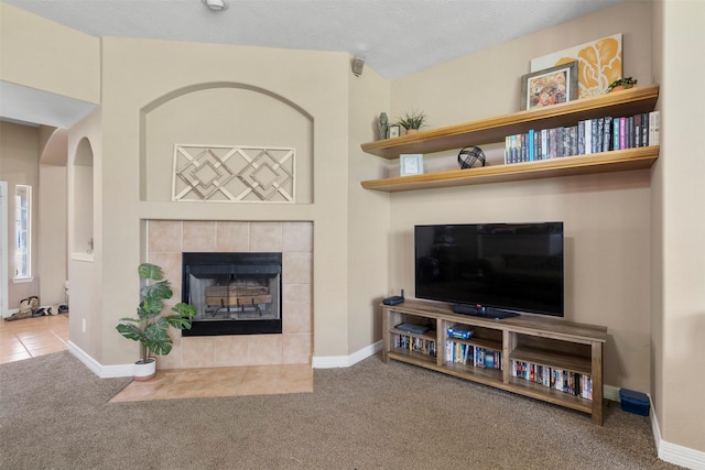 1814 Caroline Ave, Baytown, TX 77523 - living room featuring carpet flooring, a tiled fireplace, and baseboards