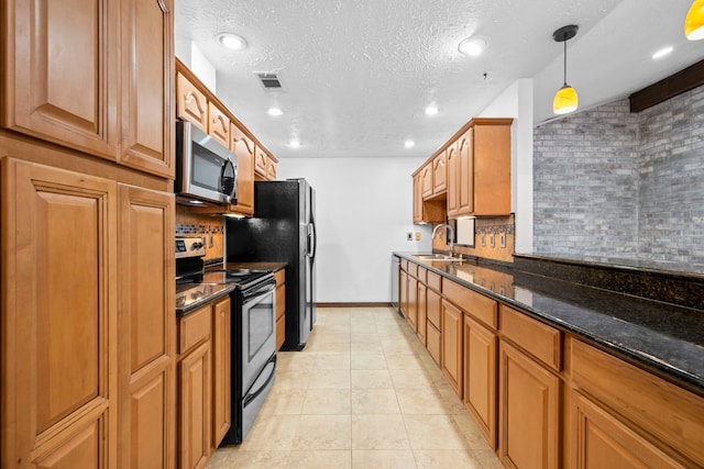 10507 Stockman Ln, Sugar Land, TX 77498 - kitchen featuring appliances with stainless steel finishes, a sink, tasteful backsplash, baseboards, and dark stone counters