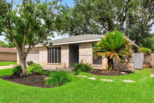 10507 Stockman Ln, Sugar Land, TX 77498 - view of front of home featuring a front lawn, brick siding, and an attached garage