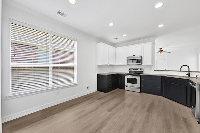 21357 Thurston Crossing Dr, Porter, TX 77365 - kitchen with appliances with stainless steel finishes, a sink, white cabinets, ceiling fan, and light wood finished floors