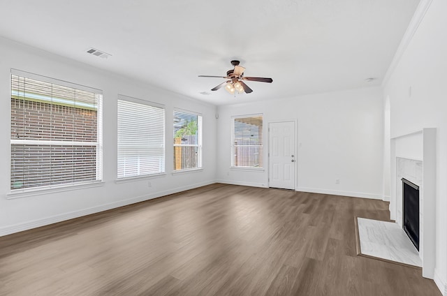 21357 Thurston Crossing Dr, Porter, TX 77365 - unfurnished living room featuring ceiling fan, wood finished floors, a premium fireplace, and baseboards