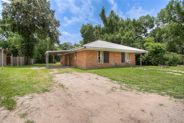 712 E Morris St, Madisonville, TX 77864 - view of front facade featuring dirt driveway, brick siding, an attached carport, and cooling unit