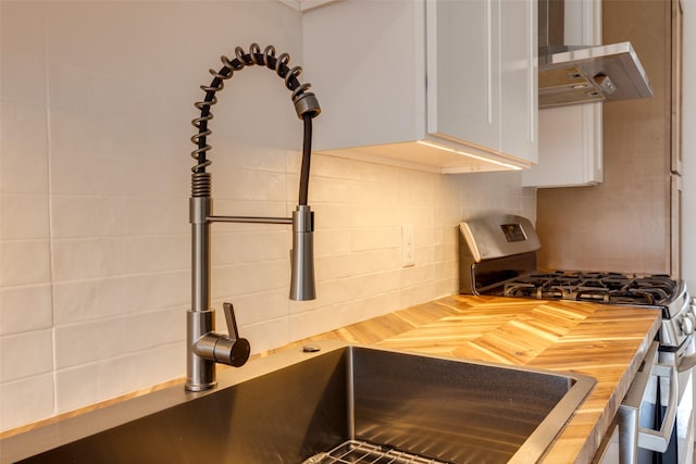 1730 Wakefield Dr, Houston, TX 77018 - kitchen featuring stainless steel gas stove, butcher block countertops, wall chimney range hood, and tasteful backsplash