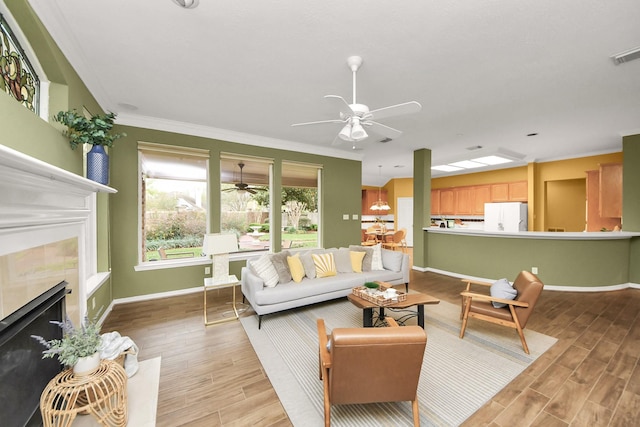 1542 Orchard Park Dr, Houston, TX 77077 - living room featuring a ceiling fan, a tile fireplace, ornamental molding, baseboards, and light wood-style floors