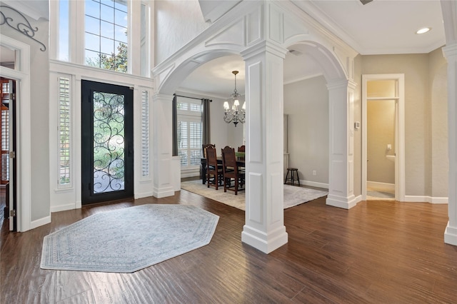 9611 Stonebridge Pl, Tomball, TX 77375 - entrance foyer with arched walkways, ornate columns, a chandelier, ornamental molding, and plenty of natural light
