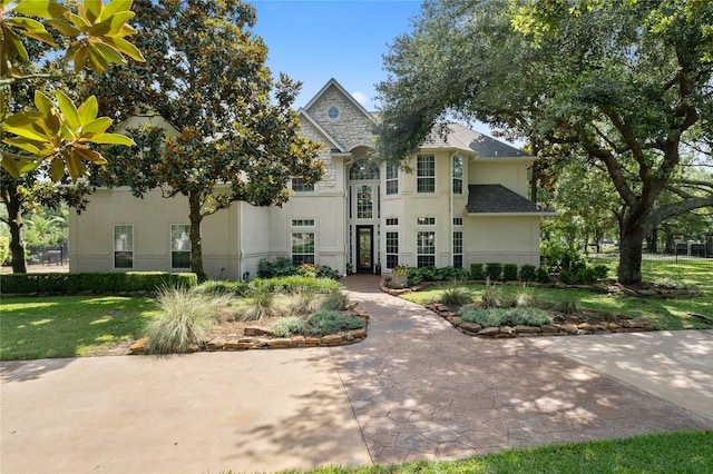 9611 Stonebridge Pl, Tomball, TX 77375 - view of front facade with stucco siding, a front yard, and roof with shingles