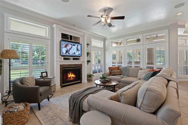 9611 Stonebridge Pl, Tomball, TX 77375 - living area with light tile patterned floors, a premium fireplace, crown molding, and ceiling fan