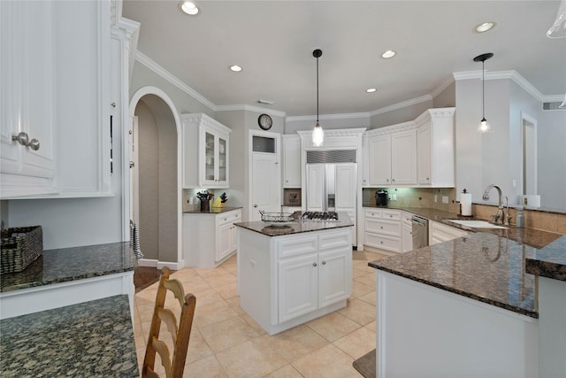 9611 Stonebridge Pl, Tomball, TX 77375 - kitchen featuring a sink, stainless steel appliances, light tile patterned flooring, dark stone counters, and backsplash