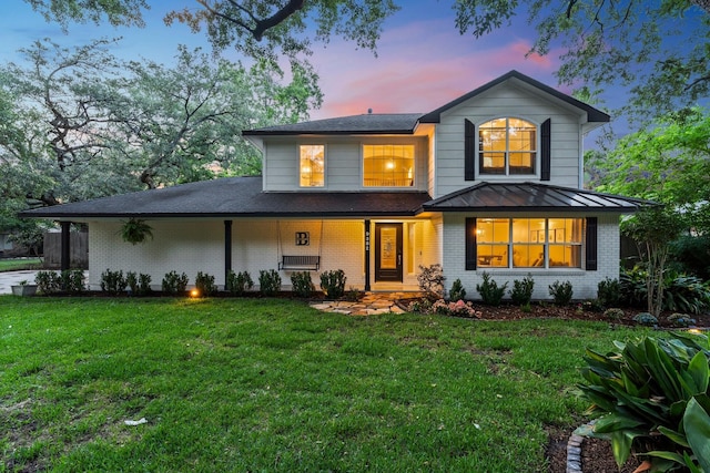 9382 Livernois Rd, Houston, TX 77080 - view of front of home featuring brick siding, a front lawn, a standing seam roof, and covered porch