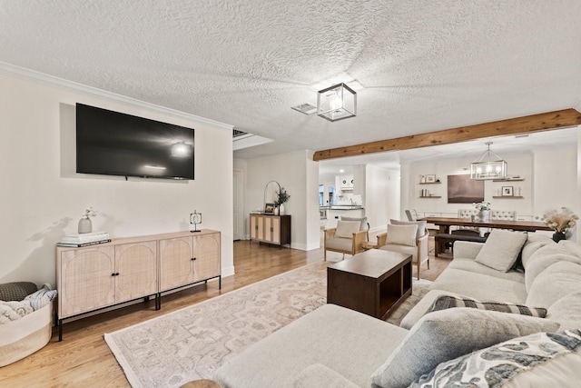 9382 Livernois Rd, Houston, TX 77080 - living area featuring wood finished floors, a textured ceiling, a chandelier, and ornamental molding