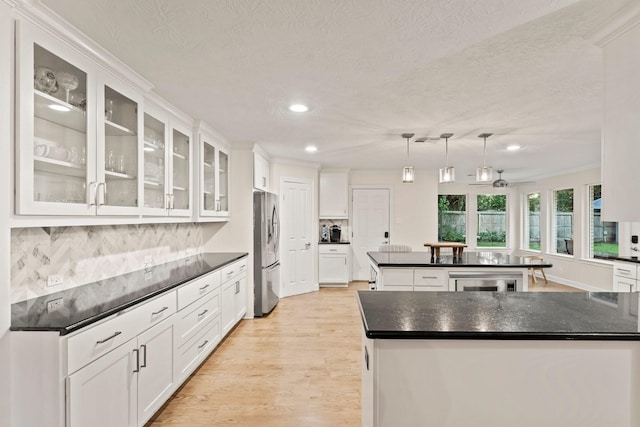 9382 Livernois Rd, Houston, TX 77080 - kitchen featuring freestanding refrigerator, a kitchen island, dark countertops, recessed lighting, and a textured ceiling