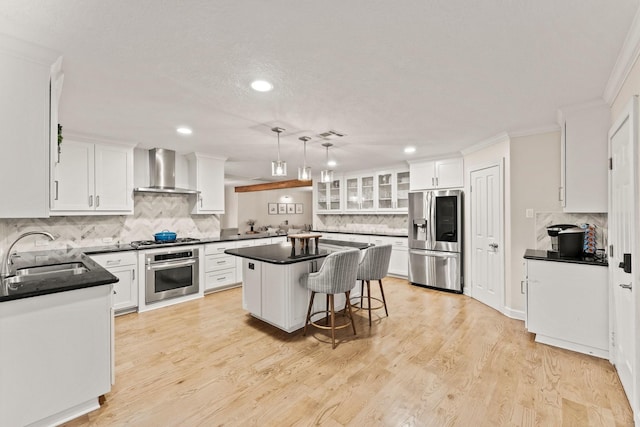 9382 Livernois Rd, Houston, TX 77080 - kitchen with appliances with stainless steel finishes, a sink, wall chimney range hood, backsplash, and white cabinets