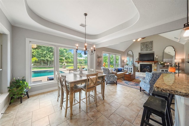 5112 E Settlers Bnd, Montgomery, TX 77316 - dining area featuring a glass covered fireplace, a chandelier, a tray ceiling, and baseboards