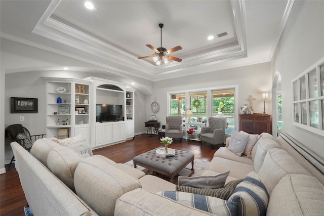 5112 E Settlers Bnd, Montgomery, TX 77316 - living area with a tray ceiling, a ceiling fan, dark wood-style floors, crown molding, and arched walkways