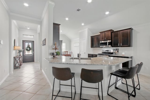 4609 Autumn Morning Dr, Spring, TX 77386 - kitchen featuring appliances with stainless steel finishes, a sink, a breakfast bar, crown molding, and dark brown cabinets