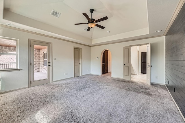 2806 King Point View Ln, Spring, TX 77388 - unfurnished bedroom with a tray ceiling, arched walkways, light carpet, and baseboards