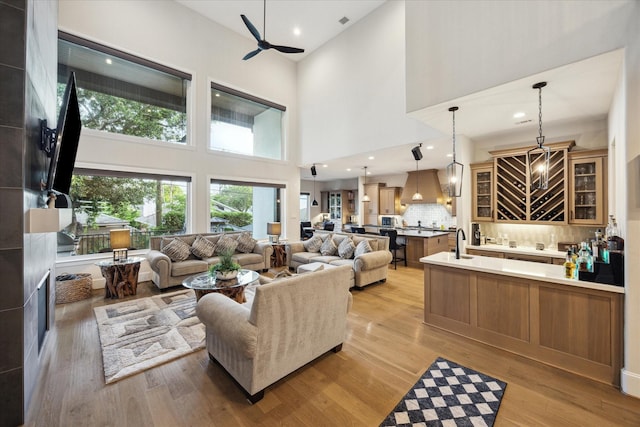4019 Drummond St, Houston, TX 77025 - living room with a ceiling fan, a towering ceiling, light wood-style floors, and recessed lighting