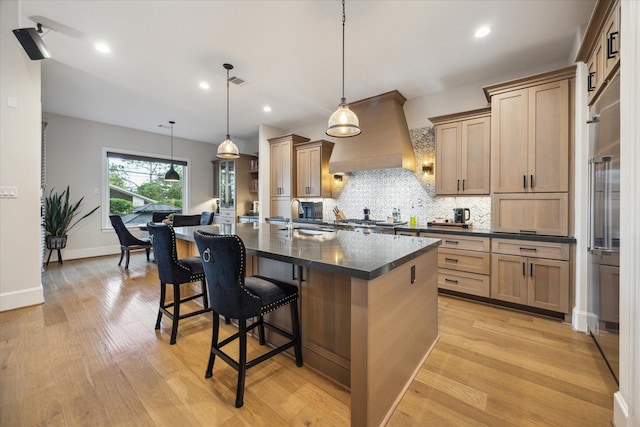 4019 Drummond St, Houston, TX 77025 - kitchen featuring dark countertops, custom exhaust hood, backsplash, light wood-style flooring, and recessed lighting