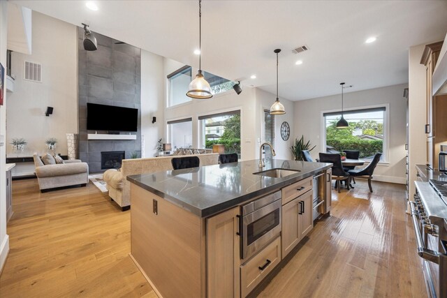 4019 Drummond St, Houston, TX 77025 - kitchen with a sink, appliances with stainless steel finishes, light wood-style floors, a kitchen island with sink, and recessed lighting