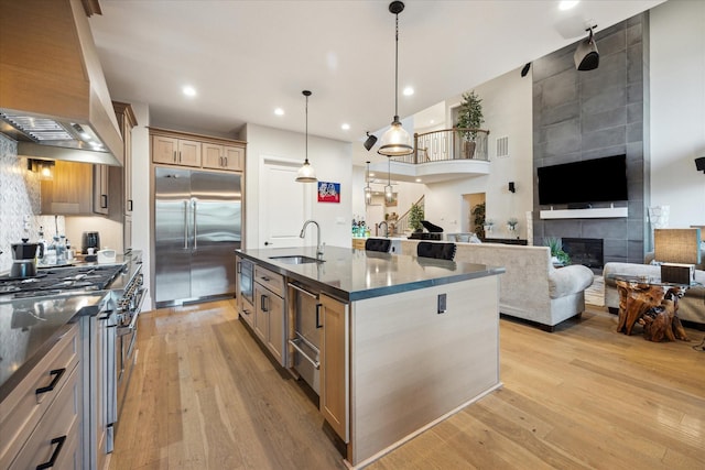 4019 Drummond St, Houston, TX 77025 - kitchen featuring built in appliances, extractor fan, a sink, light wood-style floors, and recessed lighting