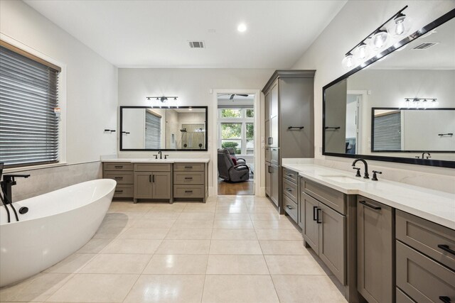 4019 Drummond St, Houston, TX 77025 - full bathroom with two vanities, a freestanding tub, and tile patterned flooring