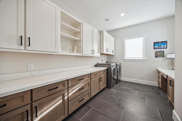 4019 Drummond St, Houston, TX 77025 - laundry room with washer and dryer, cabinet space, baseboards, recessed lighting, and dark tile patterned floors