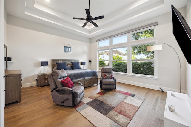 4019 Drummond St, Houston, TX 77025 - bedroom with a tray ceiling, light wood-style floors, baseboards, and a ceiling fan