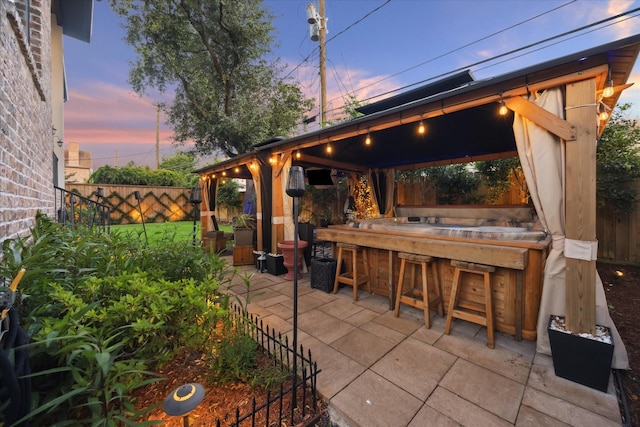 4019 Drummond St, Houston, TX 77025 - patio terrace at dusk featuring a gazebo, a fenced backyard, and a patio