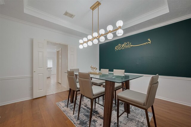 11943 Natural Bridges Ln, Sugar Land, TX 77498 - dining space with hardwood / wood-style floors, a tray ceiling, crown molding, and baseboards