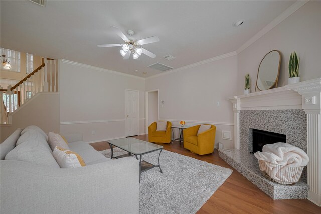 11943 Natural Bridges Ln, Sugar Land, TX 77498 - living room featuring wood finished floors, ceiling fan, ornamental molding, a fireplace with raised hearth, and stairway
