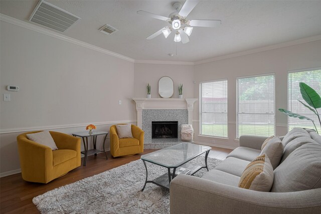 11943 Natural Bridges Ln, Sugar Land, TX 77498 - living room featuring a tile fireplace, wood finished floors, a ceiling fan, crown molding, and baseboards