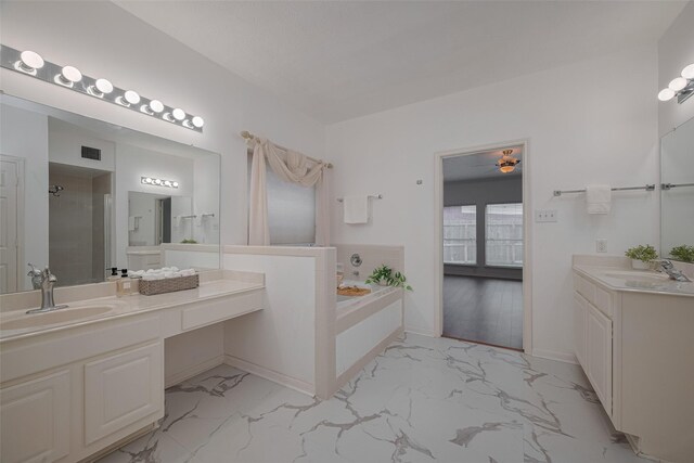 11943 Natural Bridges Ln, Sugar Land, TX 77498 - full bathroom with marble finish floors, a garden tub, two vanities, an enclosed shower, and baseboards
