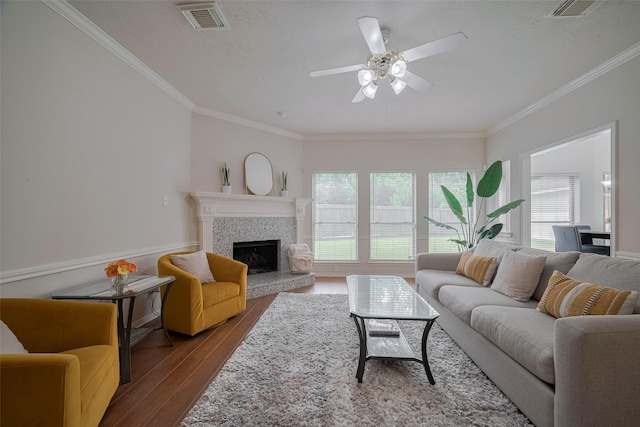 11943 Natural Bridges Ln, Sugar Land, TX 77498 - living area featuring wood finished floors, crown molding, a ceiling fan, a tile fireplace, and a textured ceiling